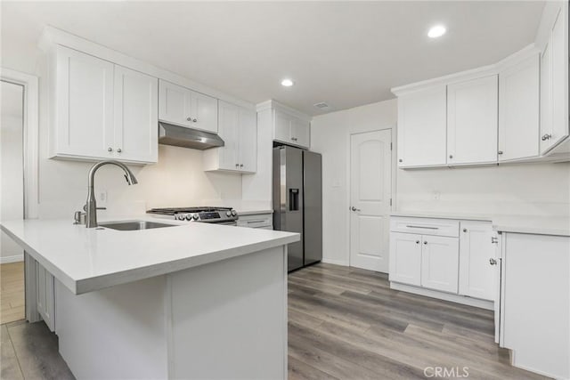 kitchen featuring white cabinets, appliances with stainless steel finishes, sink, and light hardwood / wood-style flooring