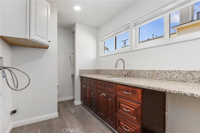 interior space featuring sink, white cabinetry, and light wood-type flooring