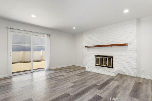 unfurnished living room featuring a fireplace and light hardwood / wood-style flooring