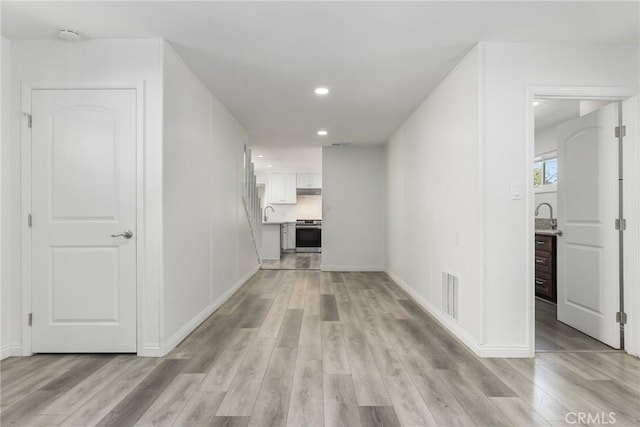 corridor with light hardwood / wood-style flooring