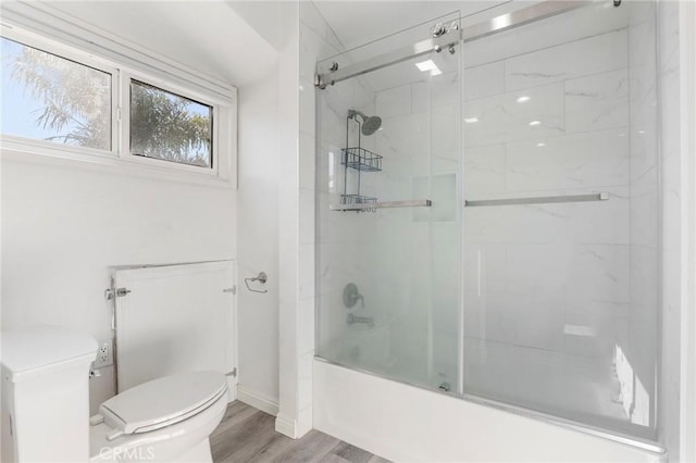 bathroom featuring toilet, shower / bath combination with glass door, and hardwood / wood-style flooring