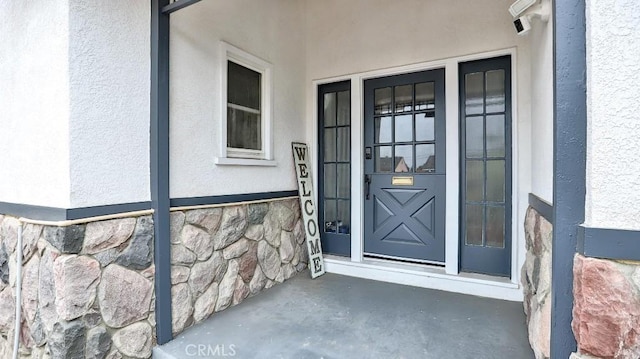 doorway to property featuring stucco siding