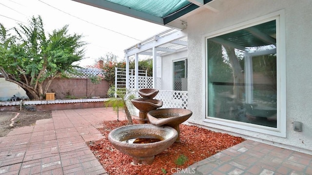 view of patio with a pergola and fence