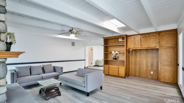 living room featuring lofted ceiling with skylight, visible vents, light wood-type flooring, and ceiling fan