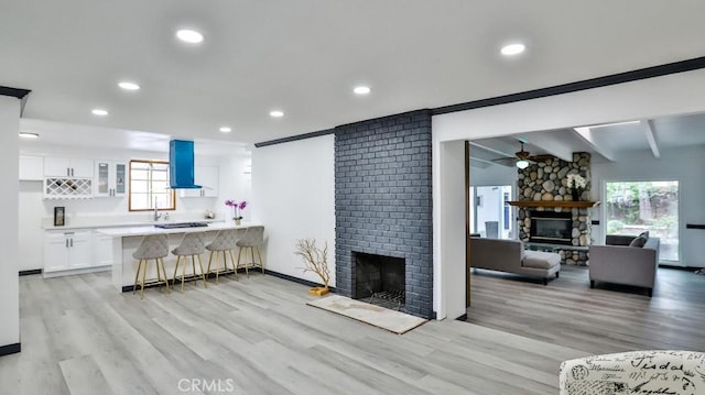 living area with a wealth of natural light, a large fireplace, and light wood-style flooring