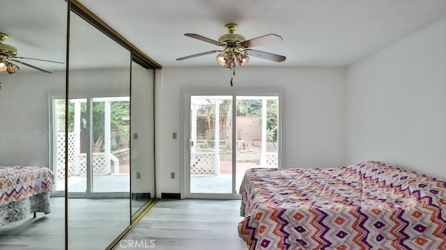 bedroom featuring access to outside, a closet, light wood finished floors, and ceiling fan