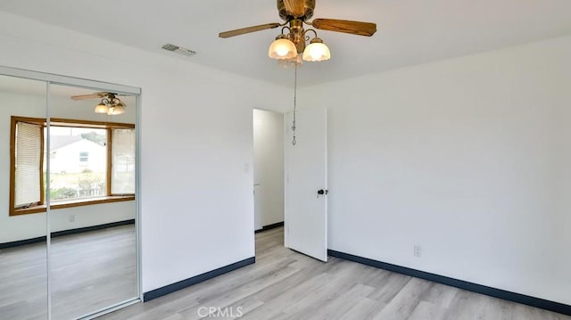 unfurnished room with baseboards, wood finished floors, and a ceiling fan