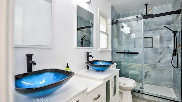 full bath featuring toilet, a stall shower, and vanity