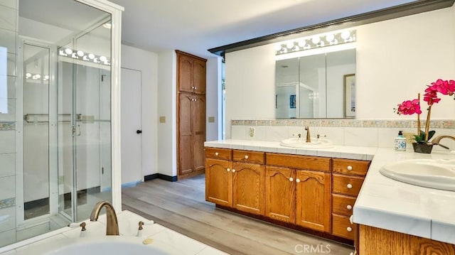 bathroom with backsplash, a stall shower, and vanity