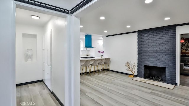 interior space featuring a fireplace, recessed lighting, wood finished floors, and baseboards