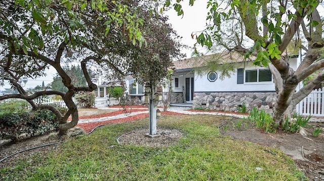 view of front of home featuring crawl space, fence, stone siding, and stucco siding