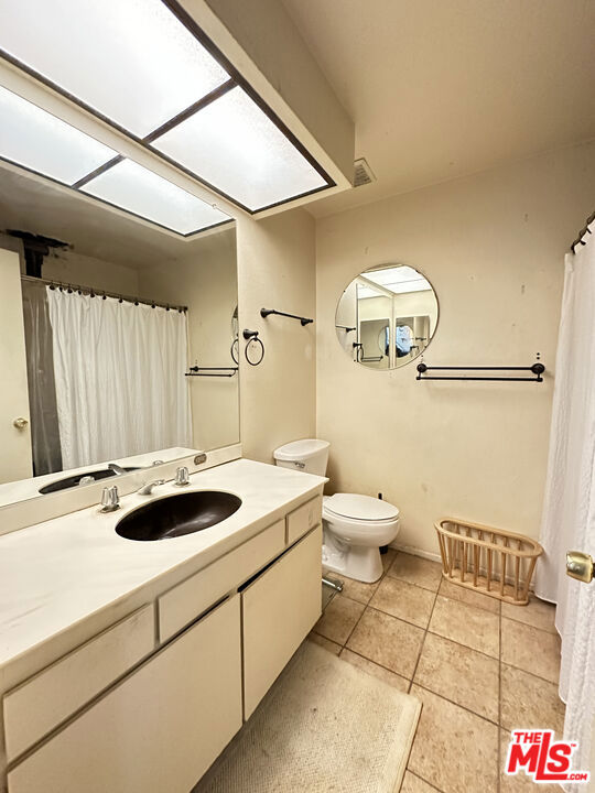 bathroom featuring vanity, toilet, and tile patterned flooring