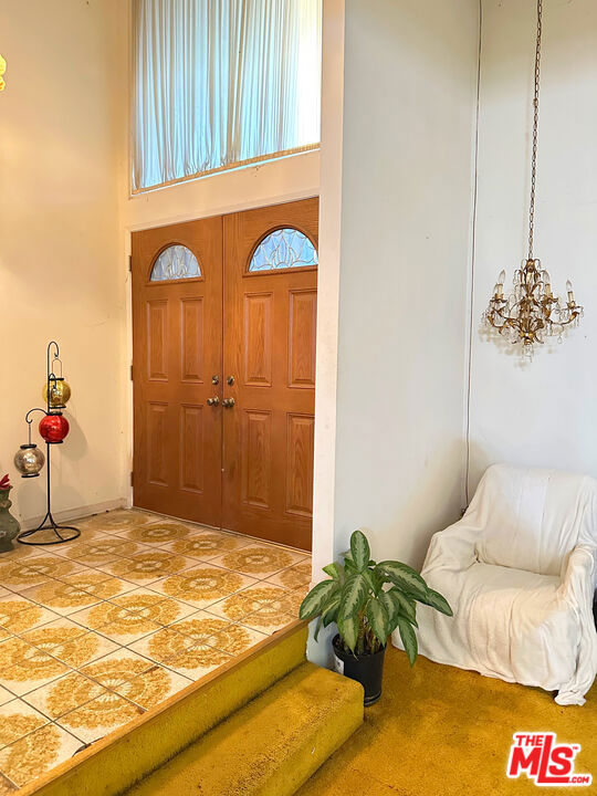 foyer entrance with a high ceiling and a chandelier