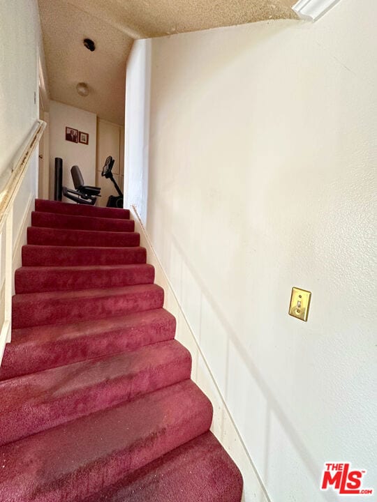 stairway with a textured ceiling