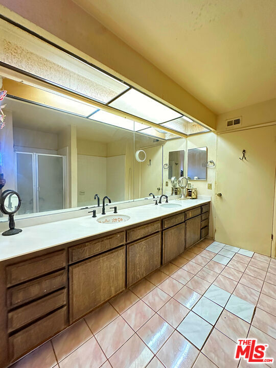 bathroom with vanity, tile patterned floors, and an enclosed shower