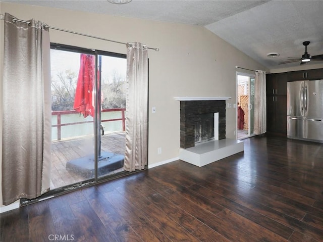 unfurnished living room with a healthy amount of sunlight, vaulted ceiling, dark hardwood / wood-style flooring, and a textured ceiling