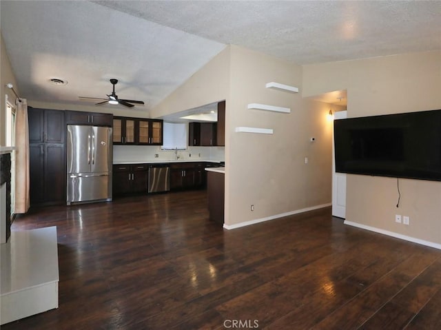 unfurnished living room with ceiling fan, dark hardwood / wood-style flooring, lofted ceiling, a textured ceiling, and sink