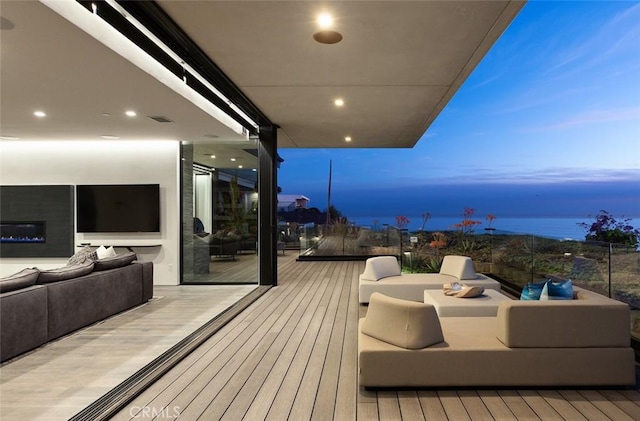 deck at dusk with outdoor lounge area