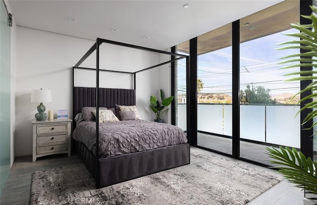 bedroom with a wall of windows and hardwood / wood-style floors