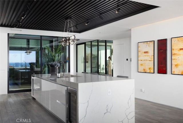 kitchen featuring wine cooler, decorative light fixtures, a chandelier, a kitchen island, and white cabinets