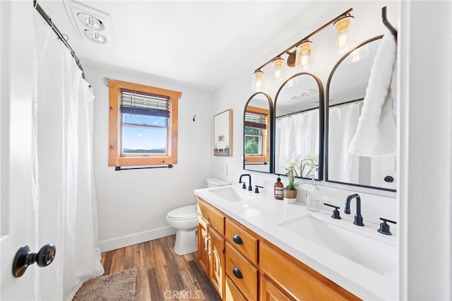 bathroom with toilet, hardwood / wood-style floors, and vanity