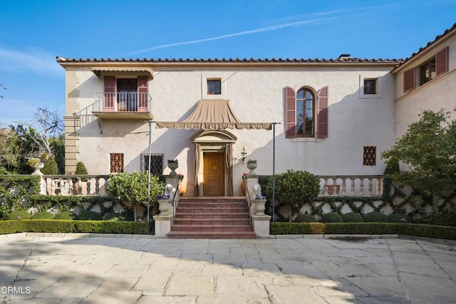 mediterranean / spanish-style home featuring a balcony and a patio