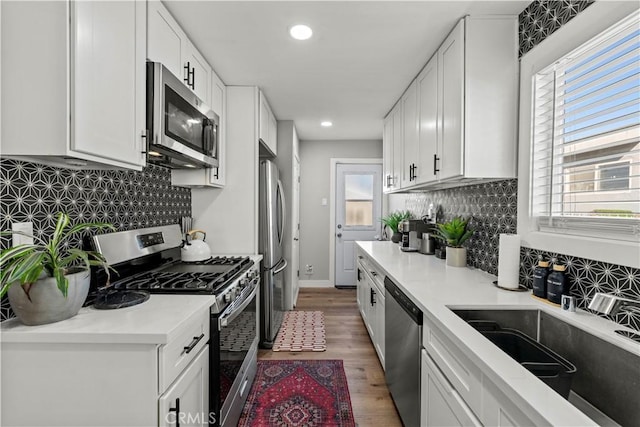 kitchen with plenty of natural light, stainless steel appliances, and white cabinets