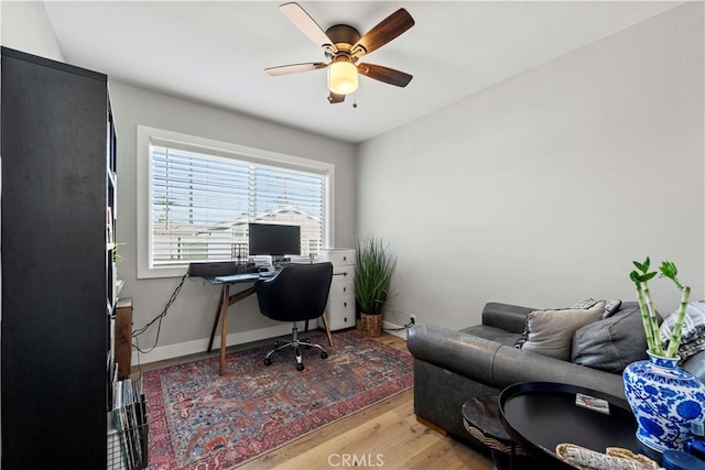 home office with ceiling fan and light hardwood / wood-style floors