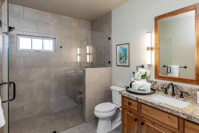 bathroom with a shower with door, toilet, vanity, and tile patterned flooring