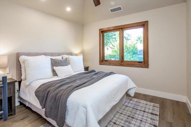 bedroom with ceiling fan, wood-type flooring, and vaulted ceiling