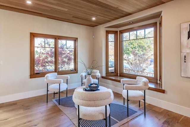 living area featuring light wood-type flooring, wood ceiling, and plenty of natural light