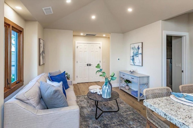 living room featuring light hardwood / wood-style flooring and vaulted ceiling