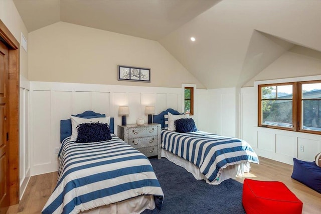 bedroom with lofted ceiling and light hardwood / wood-style floors