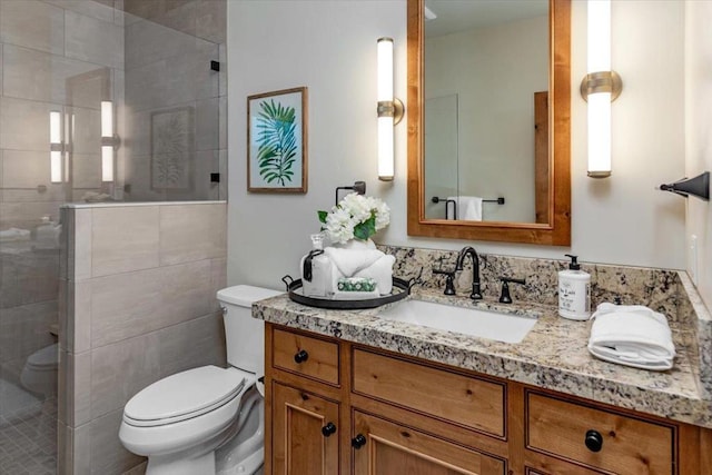 bathroom with toilet, vanity, and a shower with door