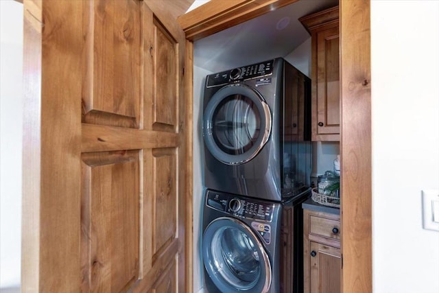 washroom featuring cabinets and stacked washer and dryer