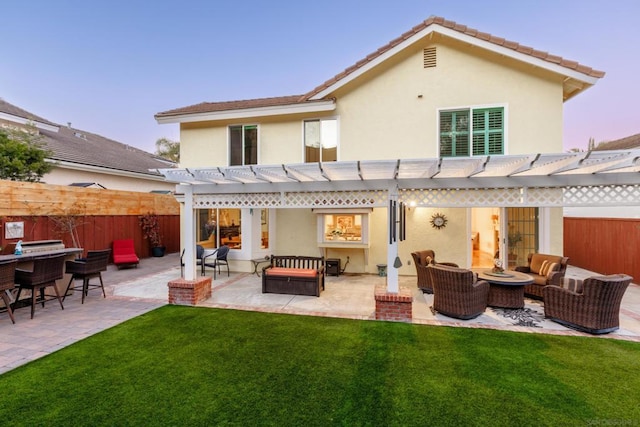 back house at dusk featuring a pergola, an outdoor living space with a fire pit, a lawn, and a patio