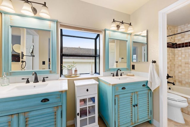 full bathroom featuring toilet, tiled shower / bath, and vanity