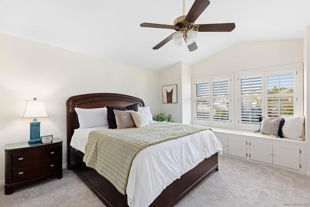 bedroom with ceiling fan, light colored carpet, and vaulted ceiling