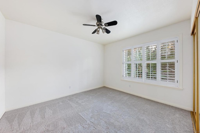 empty room featuring ceiling fan and carpet