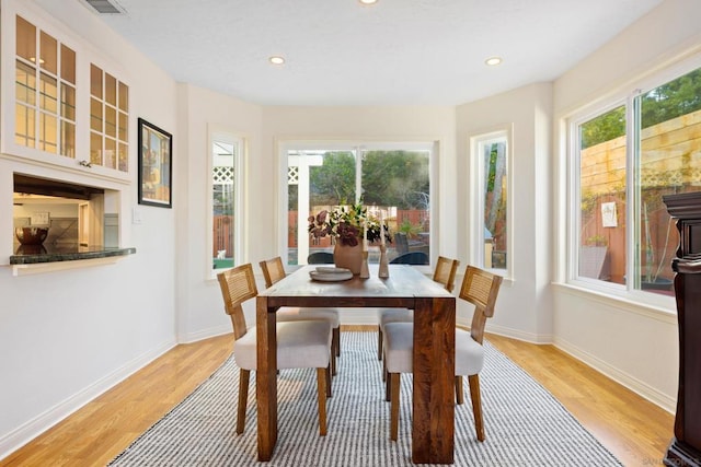 dining area with light wood-type flooring and a wealth of natural light