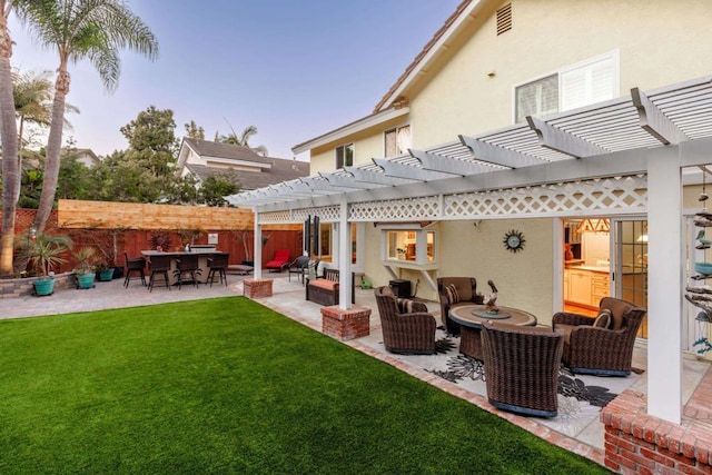 back house at dusk with a patio area, outdoor lounge area, a lawn, and a pergola