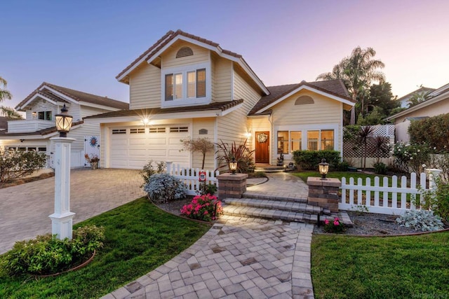 front of property featuring a garage and a lawn