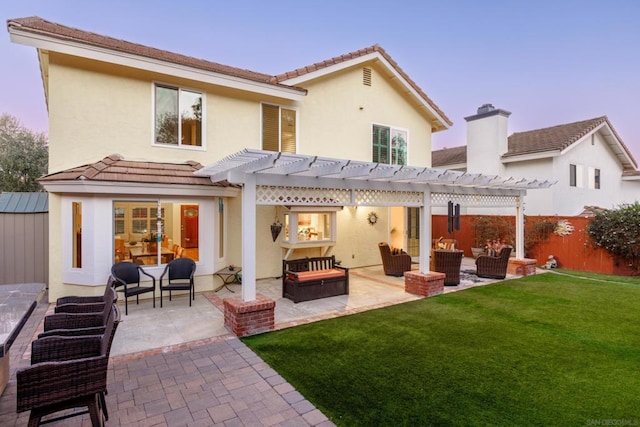 back house at dusk with a patio area, a pergola, a yard, and an outdoor living space with a fire pit