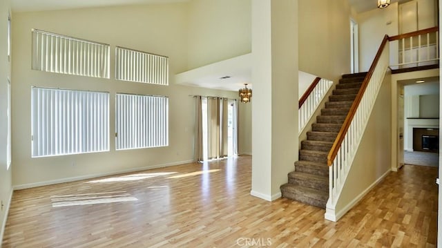 interior space featuring a high ceiling, a notable chandelier, and light hardwood / wood-style flooring