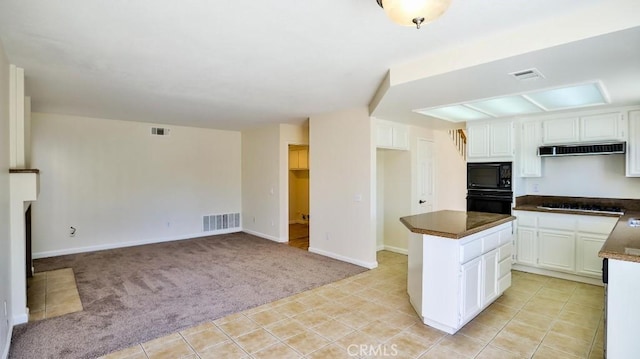 16195 Isla Maria Cir, Moreno Valley, CA 92551 - kitchen featuring under cabinet range hood, visible vents, black appliances, and light colored carpet