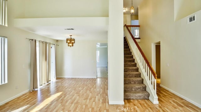 16195 Isla Maria Cir, Moreno Valley, CA 92551 - stairway with wood finished floors, visible vents, baseboards, and an inviting chandelier