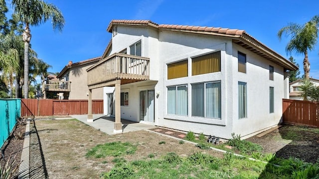 rear view of property with a patio and a balcony