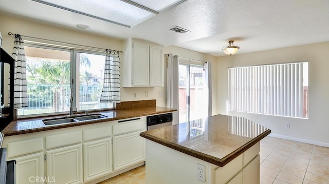 kitchen featuring light tile patterned flooring, a kitchen island, sink, and white cabinets