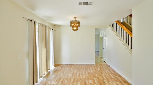 16195 Isla Maria Cir, Moreno Valley, CA 92551 - empty room featuring stairway, light wood-type flooring, baseboards, a notable chandelier, and visible vents