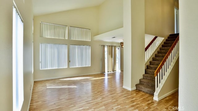 interior space with light wood-type flooring and high vaulted ceiling